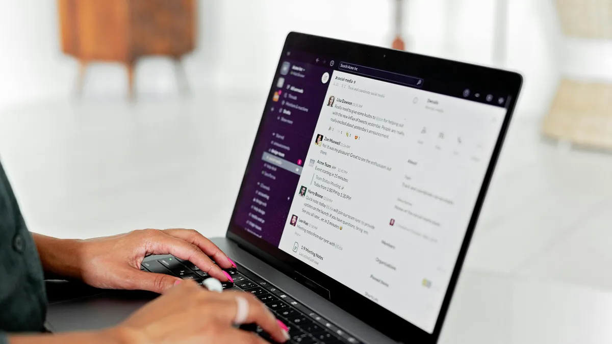 Femme tapant sur un ordinateur portable, gestion de sa messagerie dans un bureau lumineux