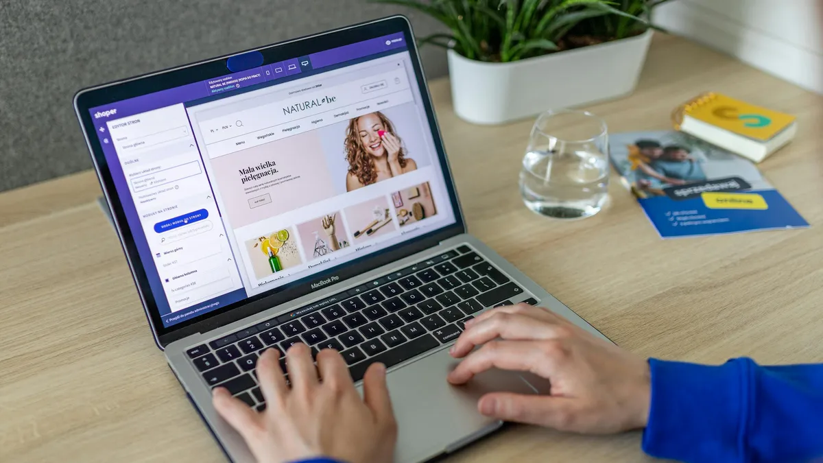 Mains tapant sur un ordinateur portable affichant un site web e-commerce