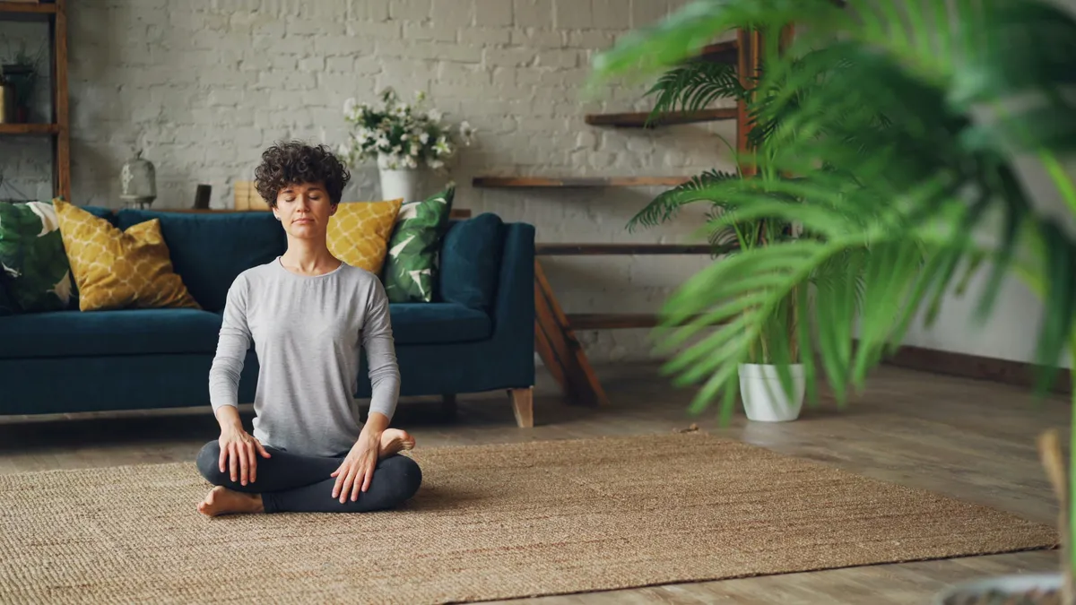 Femme en méditation dans un intérieur cosy et apaisant